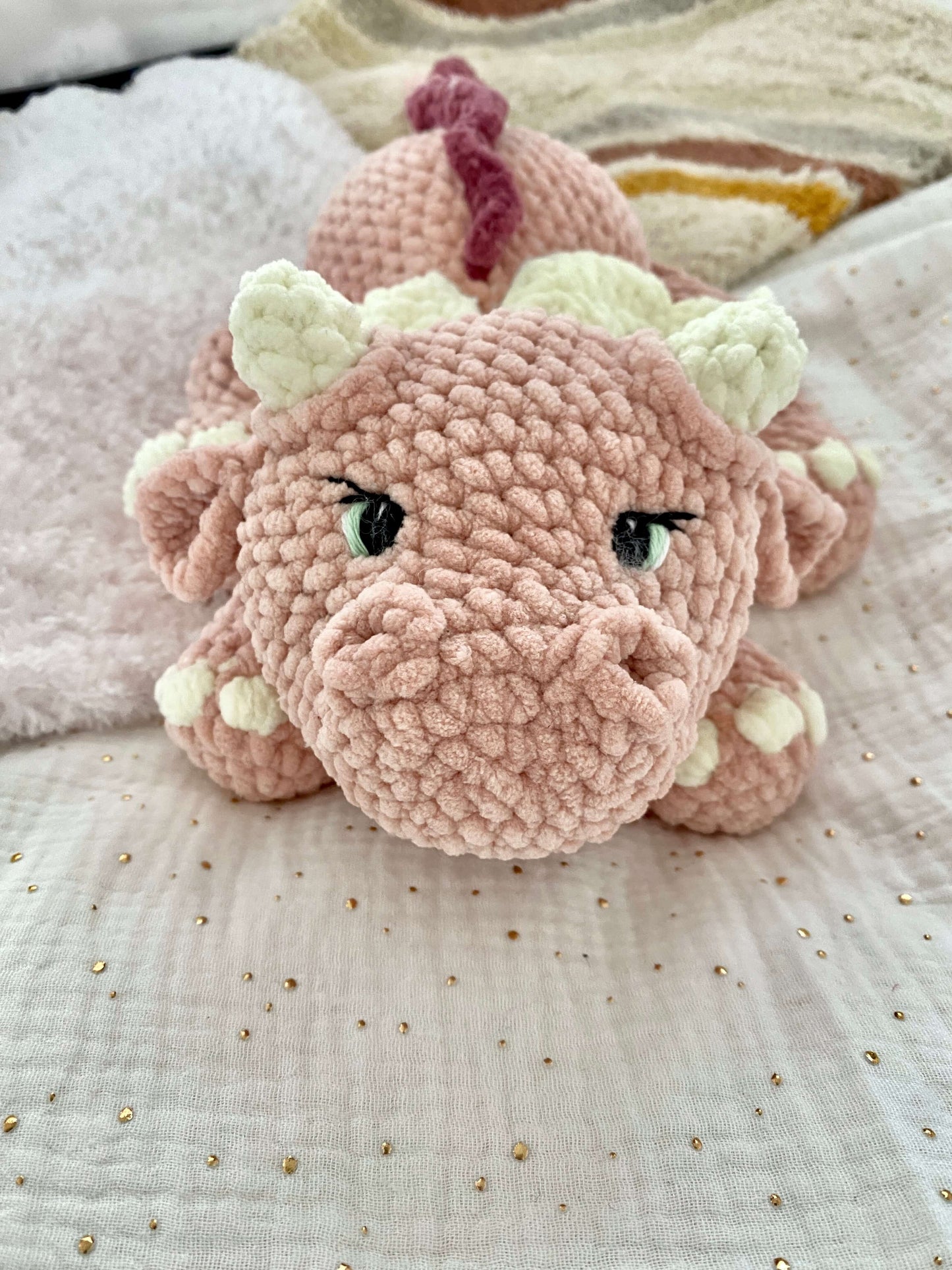 Finished Pink dragon plushie with dark rose colored ruffle on back, crochet pattern