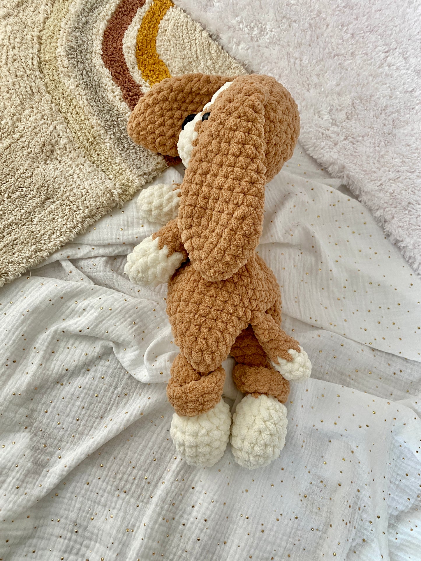 Side angle of a crochet Beagle dog lovey, snuggler, and stuffed animal, handcrafted with soft chenille yarn for kids and emotional comfort.