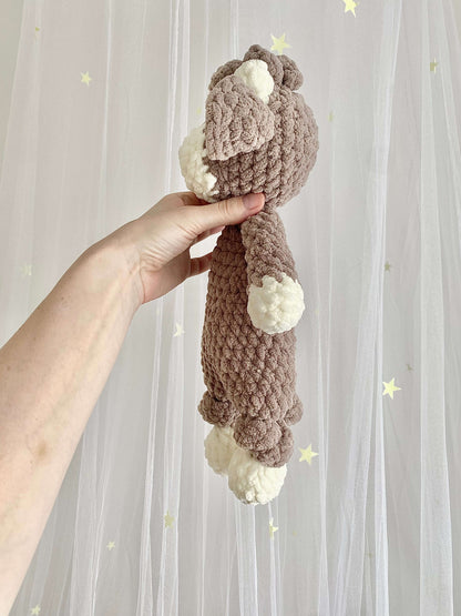 A cozy Highland Cow crochet plushie made with soft chenille yarn. The stuffed toy has shaggy fur, floppy ears, and small curved horns, making it a perfect 2-in-1 cuddly toy and lovey for kids.